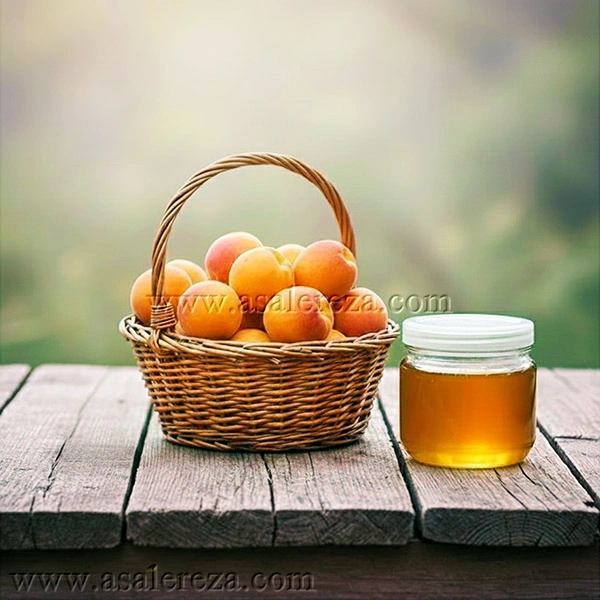زردآلوها در سبد در کنار عسل طبیعی در پت روی میز چوبی