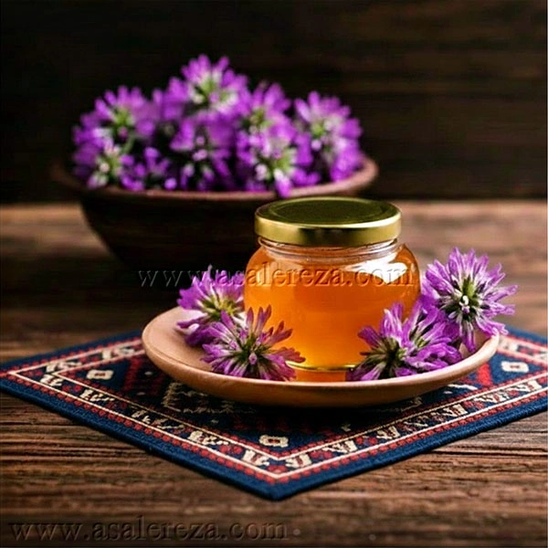 عسل طبیعی در پت شیشه ای در میان چند گل گون در بشاق چوبی روی گلیم ایرانی